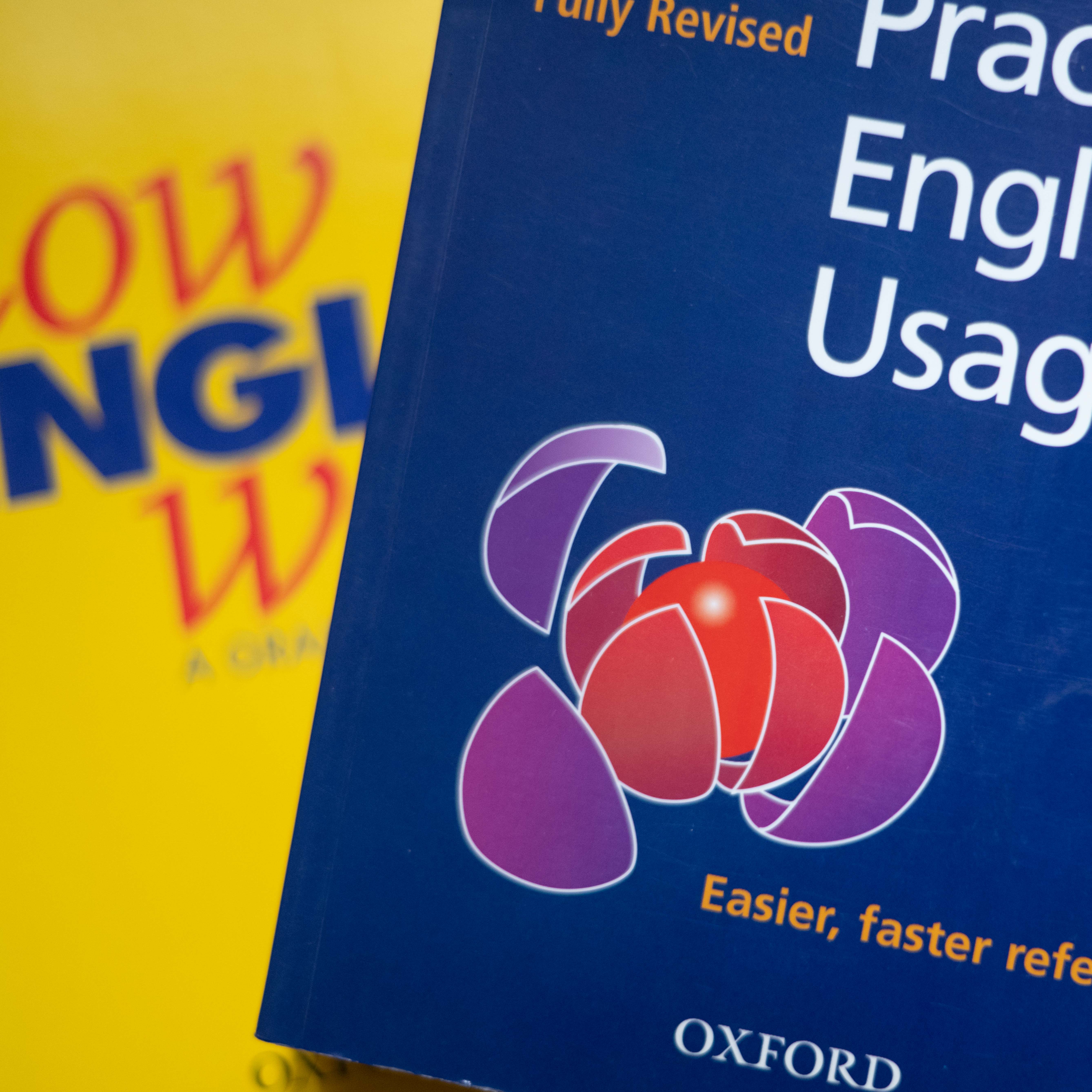 English books stacked on a wooden table